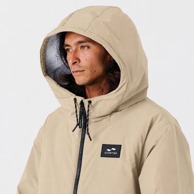 Tan insulated hooded jacket for coastal weather.