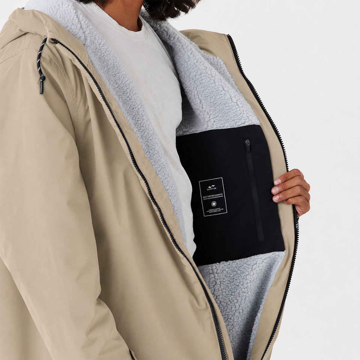 Tan coat with gray fleece lining and black inner zip pocket, shown open to display interior.