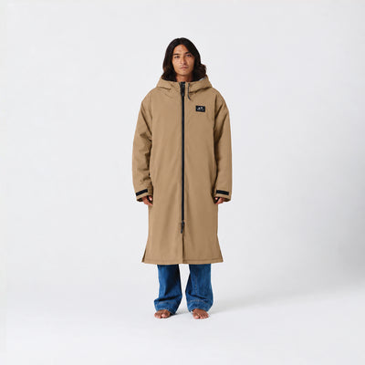 Tan waterproof parka, hip-length, with jeans displayed on plain white background.