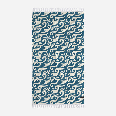 Cotton towel with ocean blue and white wave pattern, fringed edges.