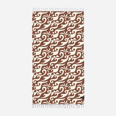 Oversized beach towel with brown and cream abstract swirls and white fringe edges.
