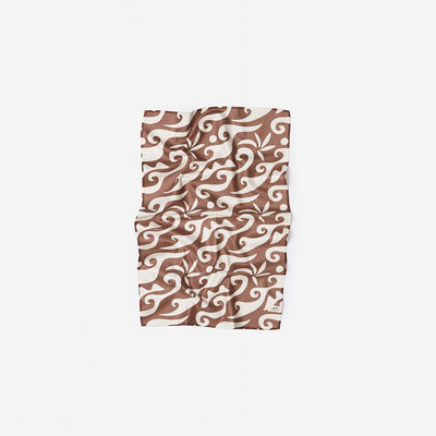 Sand resistant towel, brown and white abstract swirl pattern on white background.