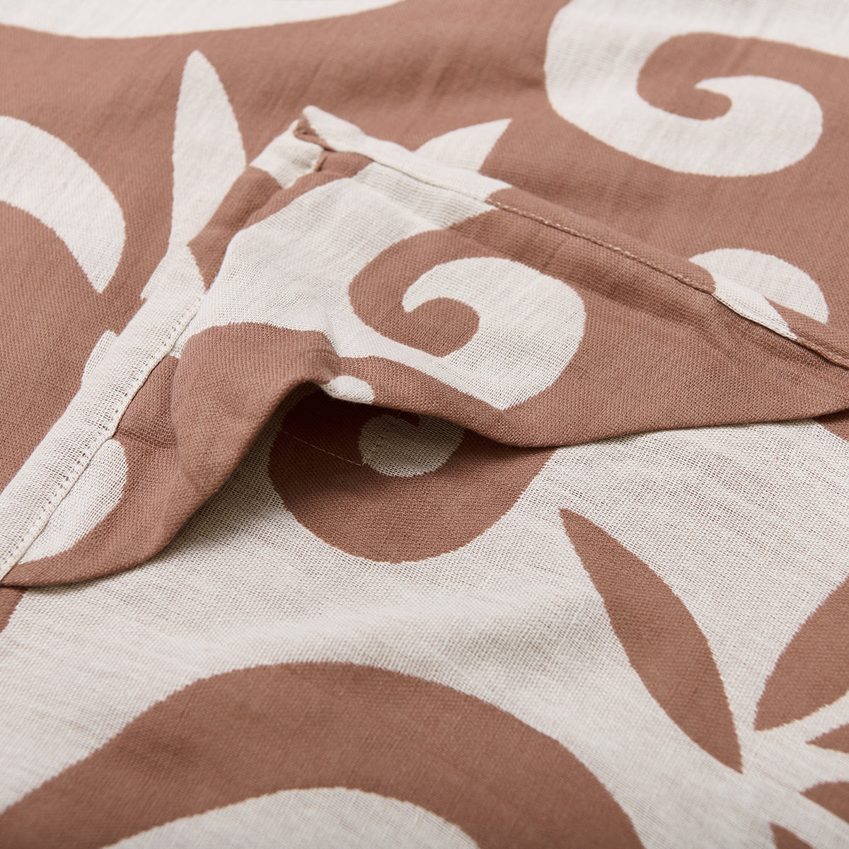 Reversible blanket with brown and white swirl pattern, visible seam detail.