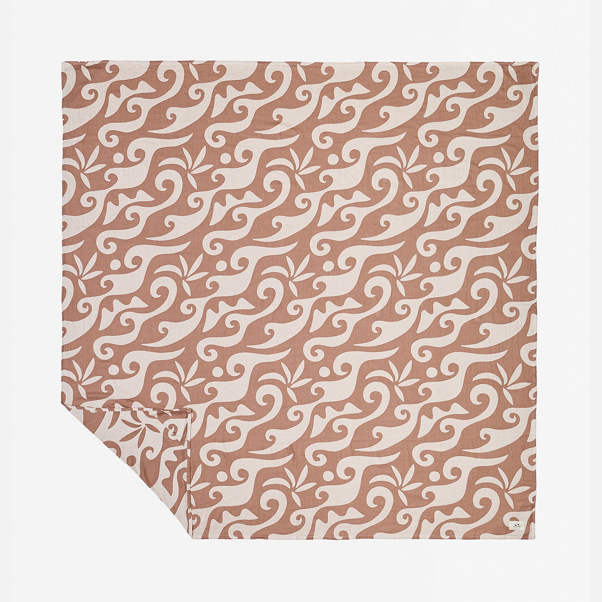 Reversible blanket with abstract beige and brown wavy floral pattern.