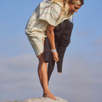 Wetsuit in lightweight, quick-dry fabric over striped shirt, outdoor setting.