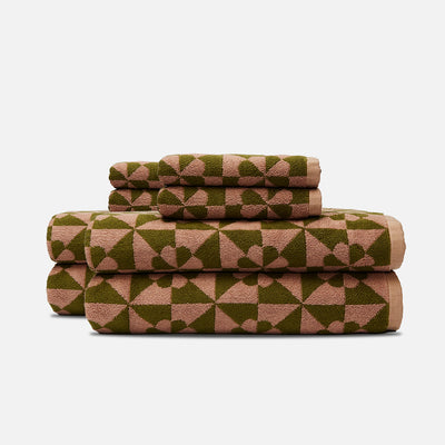 Bath towels with quilt-like texture and geometric heart pattern, stacked.