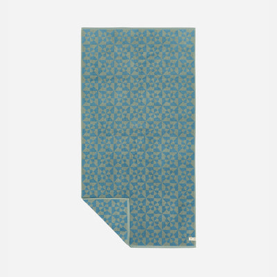 Throw blanket with dusty blue and gray geometric pattern.