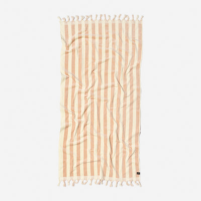 Beach towel, cotton blend, beige and white stripes with tassel fringe, flat on white surface.