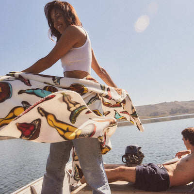 Polar fleece blanket with colorful pattern outdoors on a sunny day.