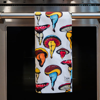 Dish towel with colorful mushroom pattern on oven handle.