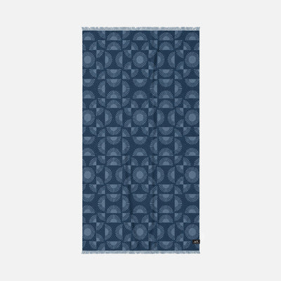 Turkish towel, sand-resistant cotton, indigo with light blue sunburst pattern and fringed edges.