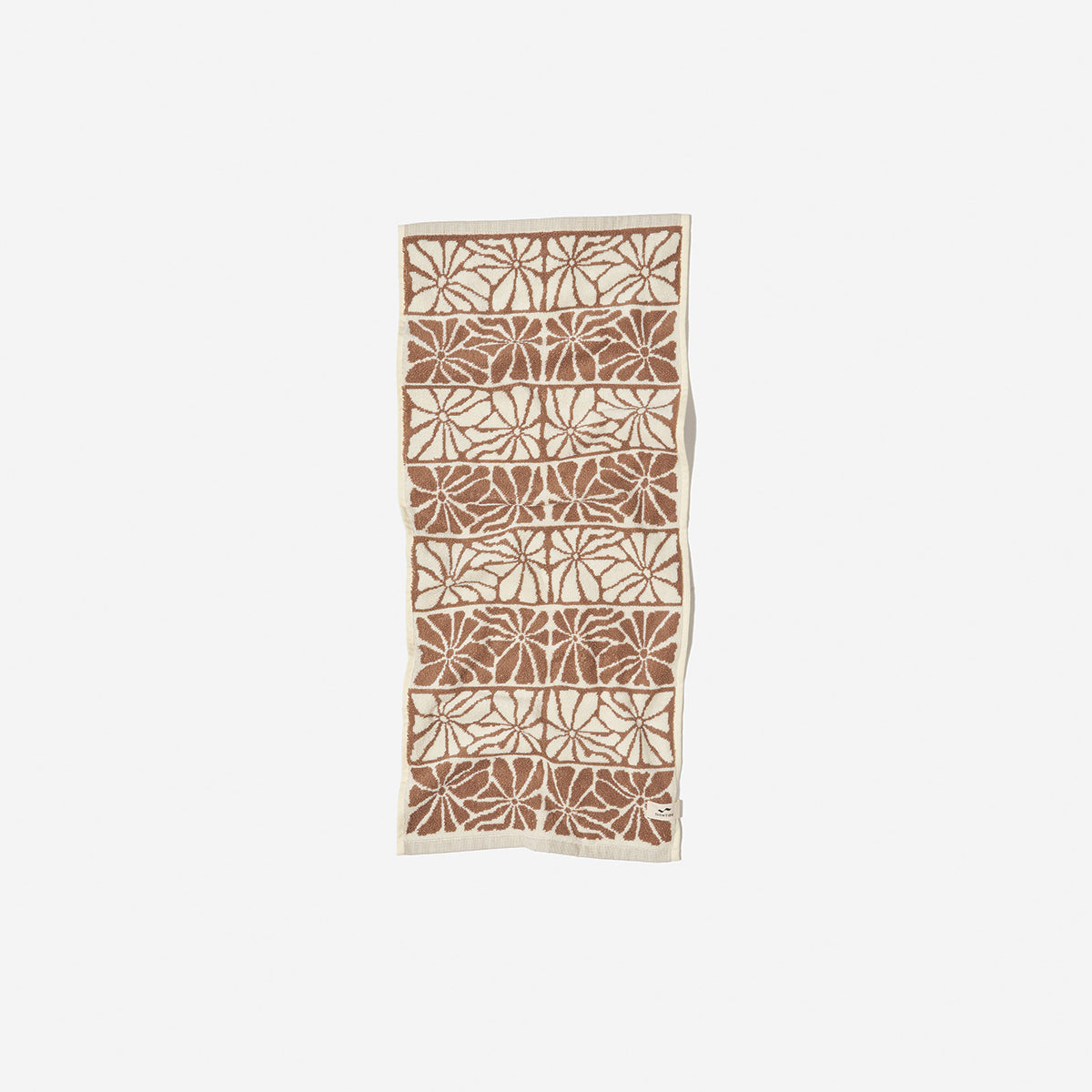 Hand towel with beige and brown abstract leaf pattern, rectangular cotton blend.