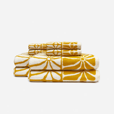 Cotton towels with bold floral pattern stacked for bathroom use.