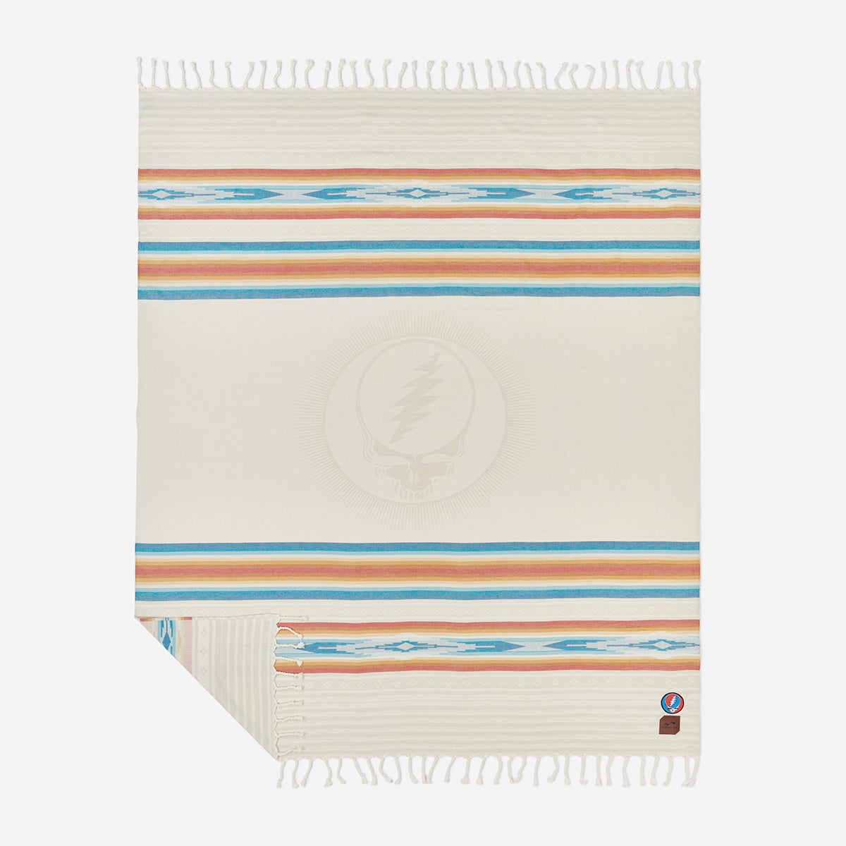 Oversized cotton blanket with blue, orange, and tan stripes and central skull logo.