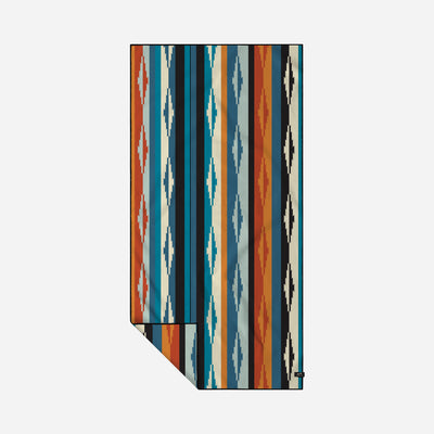 Oversized beach towel with red, blue, and beige geometric and stripe patterns.