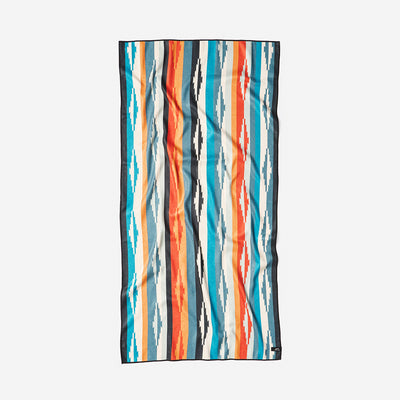 Oversized beach towel with blue, orange, and white geometric stripes.
