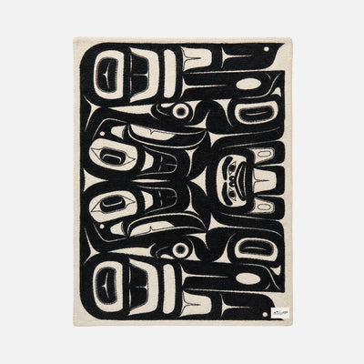 Plush reversible throw with black and white Indigenous-inspired animal pattern.