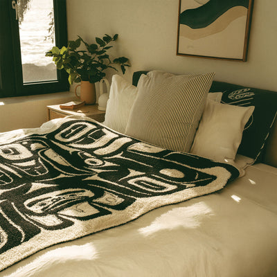 Tlingit patterned blanket on a made bed.