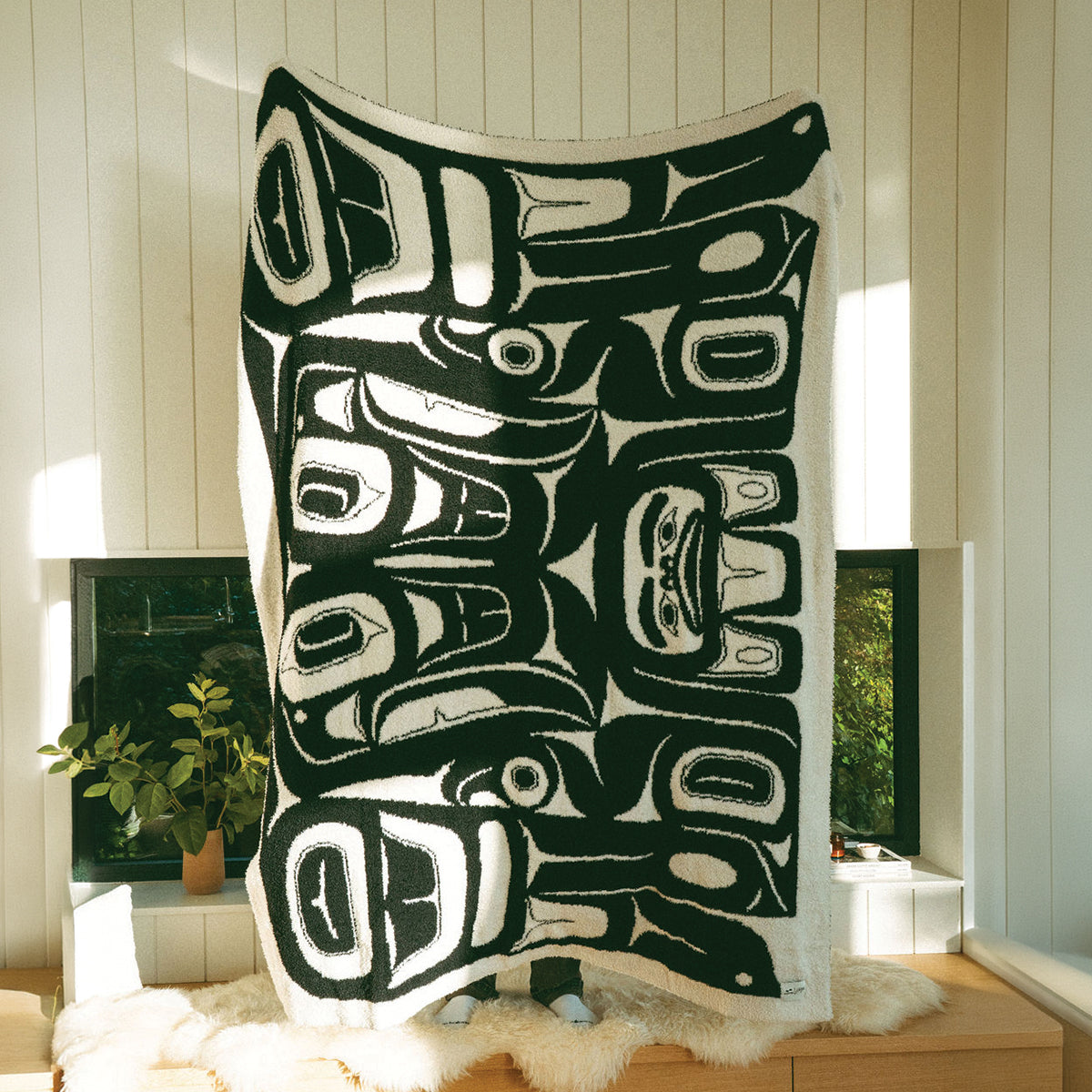Recycled polyester throw blanket with bold abstract Tlingit-inspired pattern.