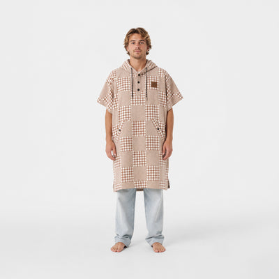 Changing poncho in sustainable cotton with a tan and white checkerboard pattern.