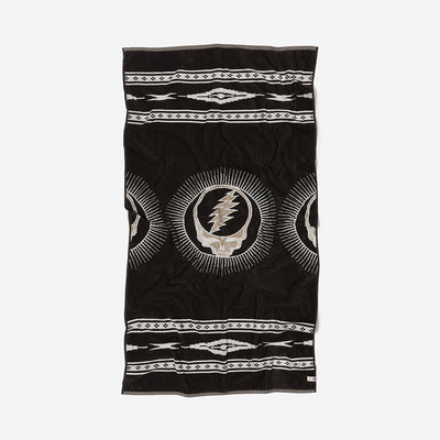 Black plush towel with white geometric and lightning skull pattern, vertical design.
