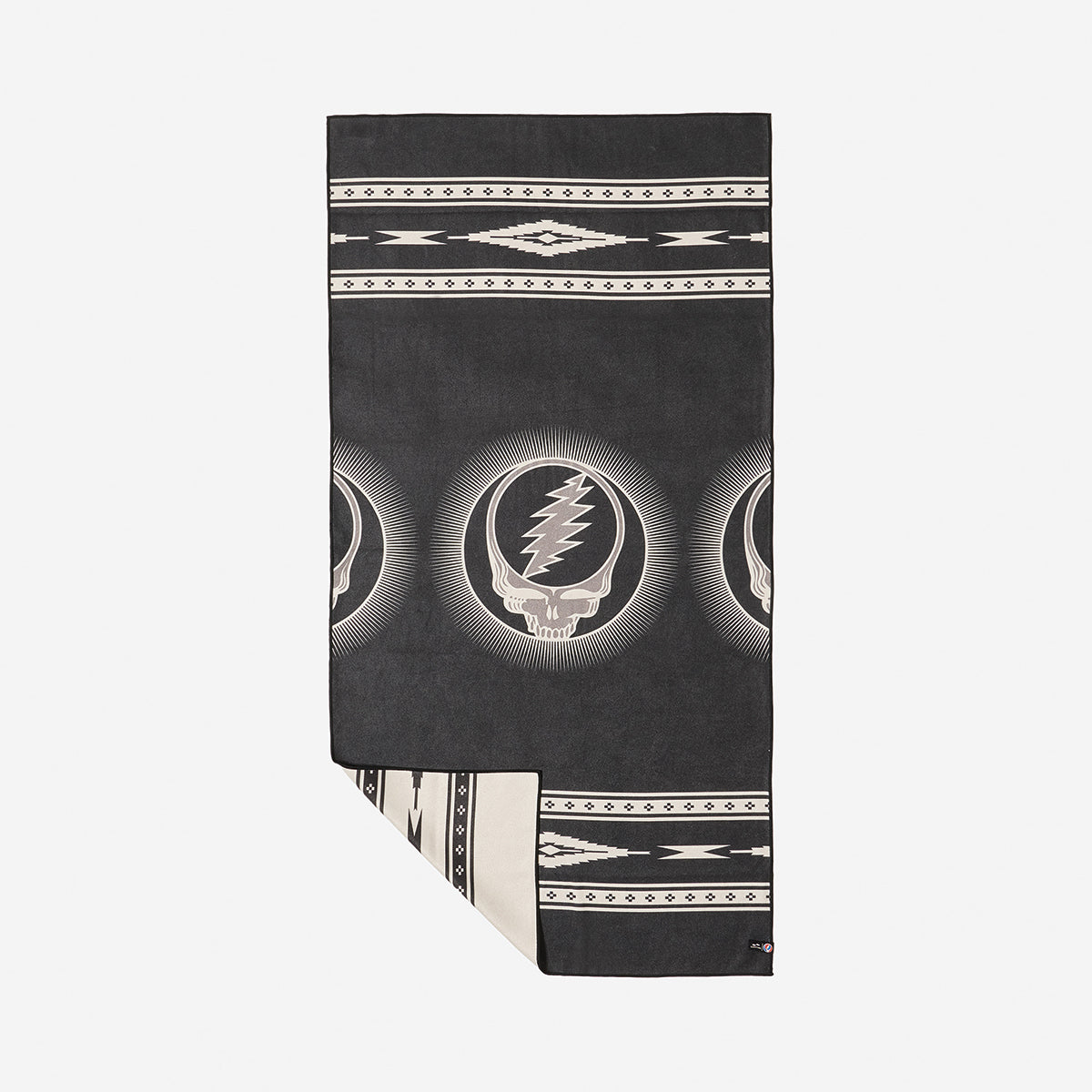 Blanket, quick-drying fabric, black and white with skull and lightning bolt pattern, corner folded.