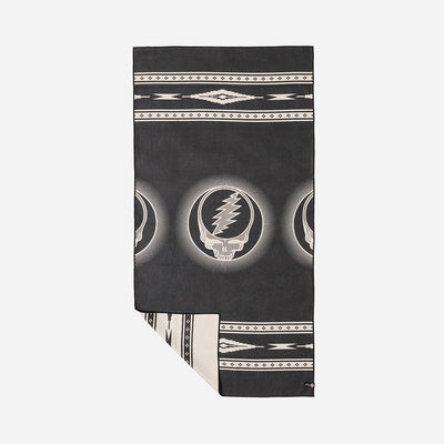 Blanket, quick-drying fabric, black and white with skull and lightning bolt pattern, corner folded.