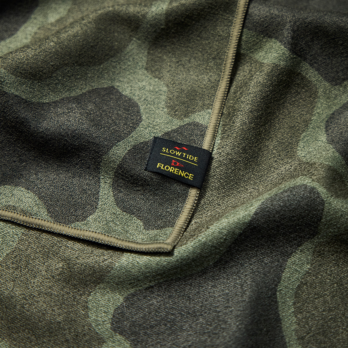 Camo print towel with sewn-on label.