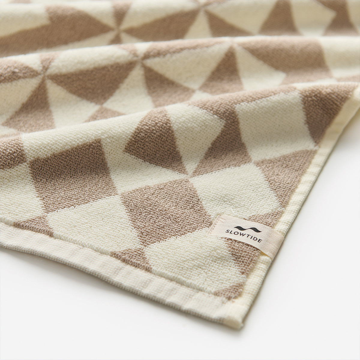 Hand towel, plush 600 GSM cotton, beige and brown geometric pattern, shown folded.