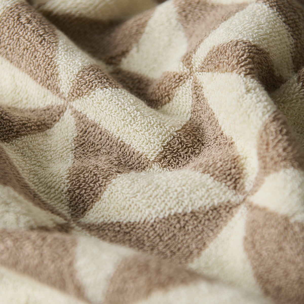 Hand towel in plush 600 GSM cotton with geometric pattern, close-up view.
