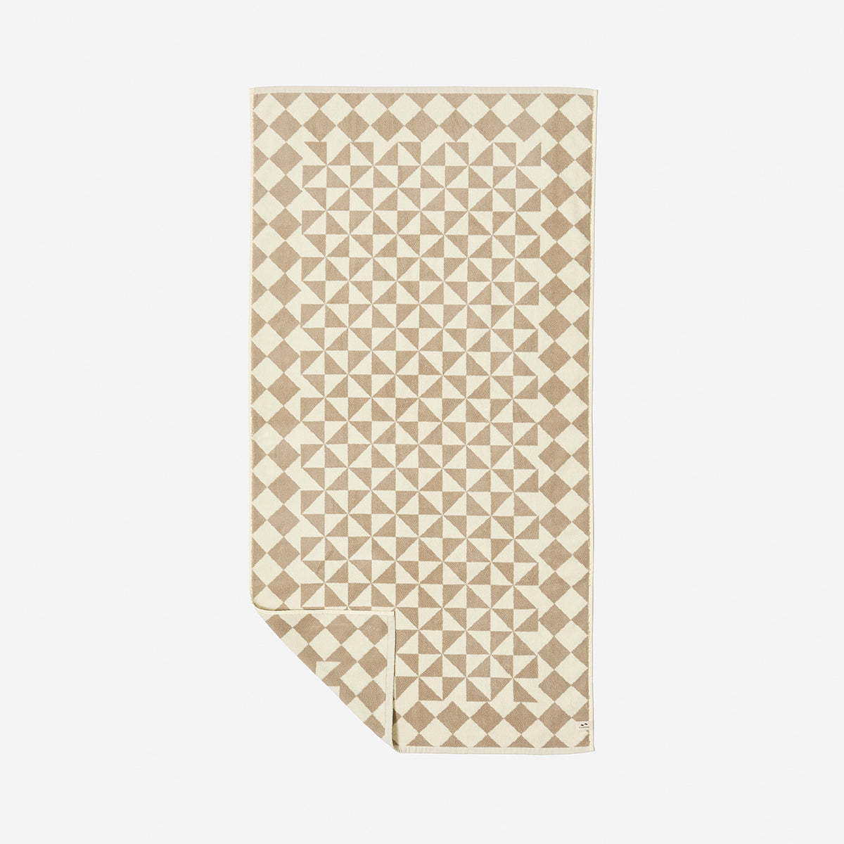 Bath towel in beige and white ultra-soft cotton with geometric pattern on display.