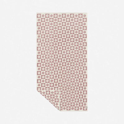 Oversized beach towel with pink and white floral geometric pattern on white background.