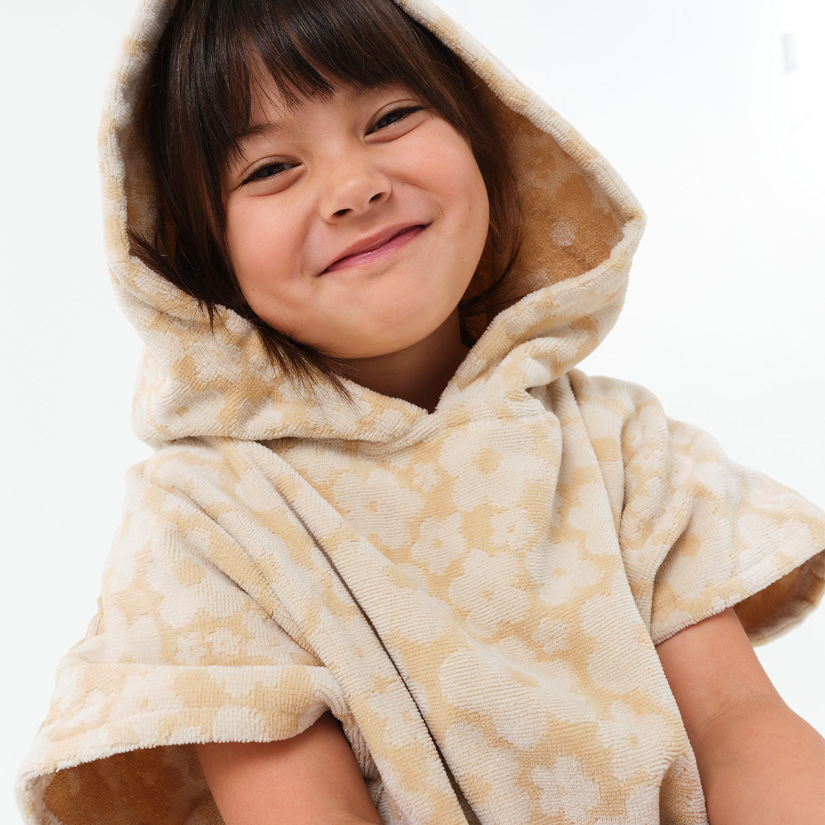 Kids poncho hooded towel, beige with floral pattern.