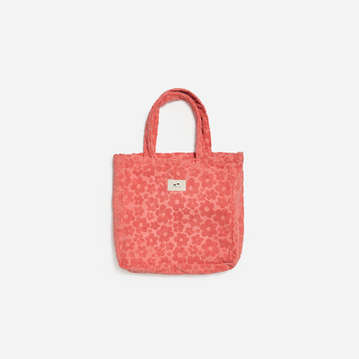 Terry tote bag with pink floral pattern and short handles.