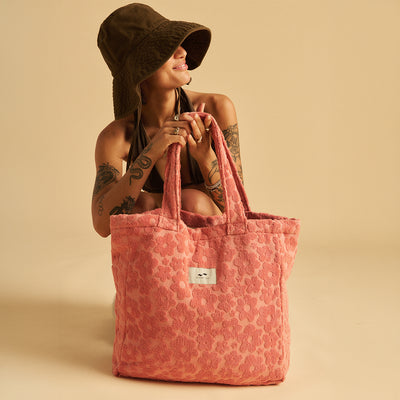 Pink floral terry tote bag with large handles.