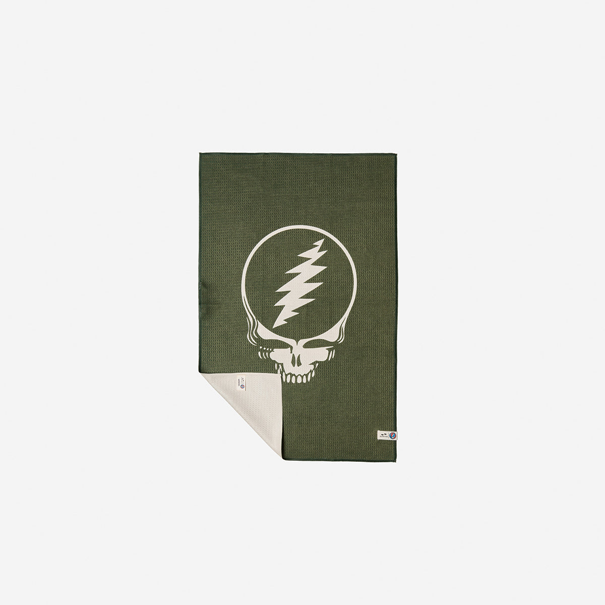 Microfiber towel in green recycled fabric with white skull and lightning bolt graphic, partially folded.