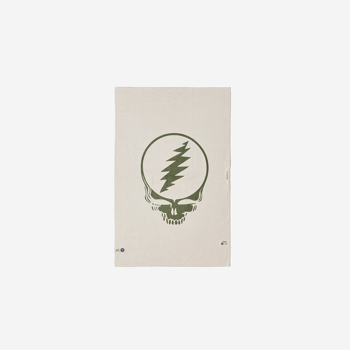 Microfiber towel in beige recycled material with central green skull and lightning bolt graphic.