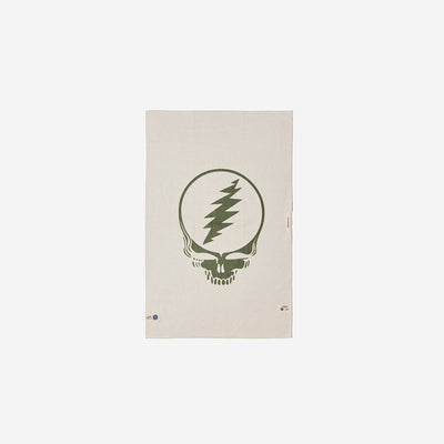 Microfiber towel in beige recycled material with central green skull and lightning bolt graphic.