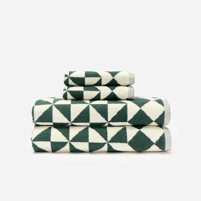 Bath towels with bold green and white geometric pattern stacked.