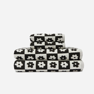 Bath towels, 100 cotton, black and white checkered with floral pattern, stacked.