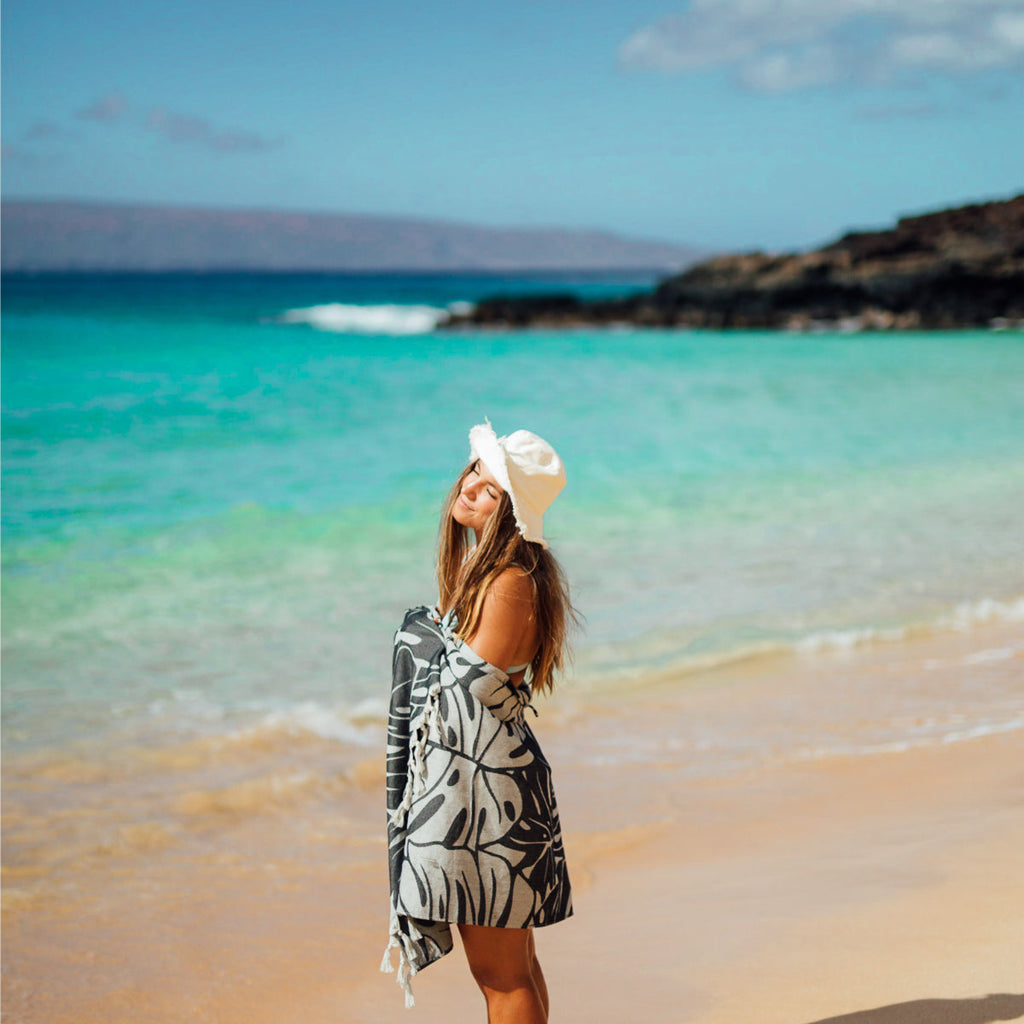 girl on tropical beach wrapped in slowtide Tarovine Turkish Towel