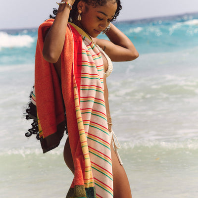 Sustainable cotton beach towel with bikini, ocean setting.