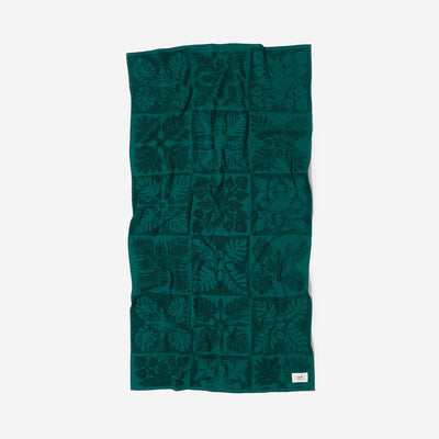 Cotton towel, green, sustainable, with textured leaf pattern, flat on white background.