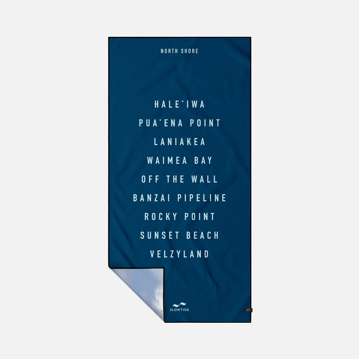 Oversized dark blue beach towel with white North Shore Oahu surf spots text pattern.