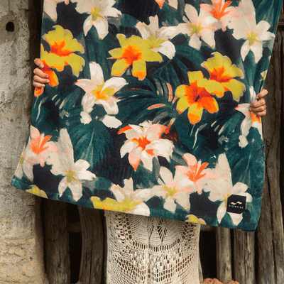 Beach towel with yellow, orange, and white floral pattern.