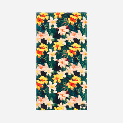 Beach towel, absorbent material, yellow orange white floral pattern on dark background.