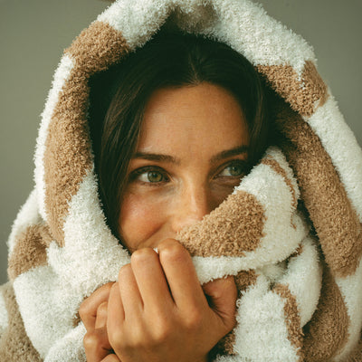Plush hooded robe in a tan and white speckled knit pattern.