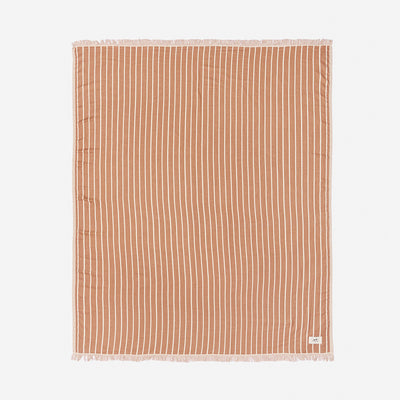 Beach blanket with white coastal stripes and fringe edging.