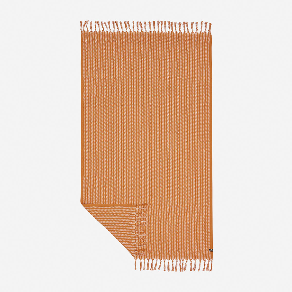 Sand resistant towel with orange stripes and fringed edges, one corner folded over.