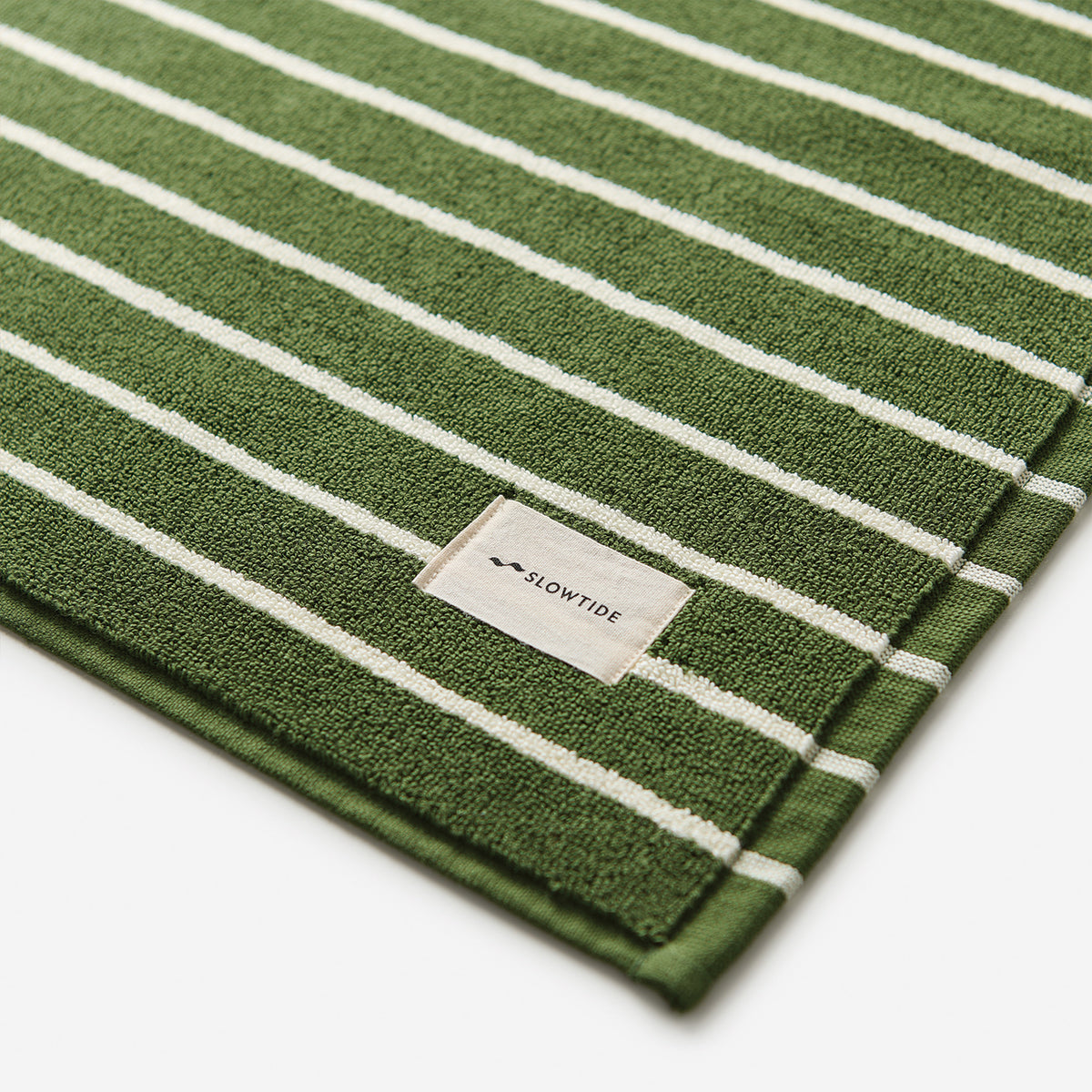 Cotton towel with green and white stripes, absorbent bath mat style.